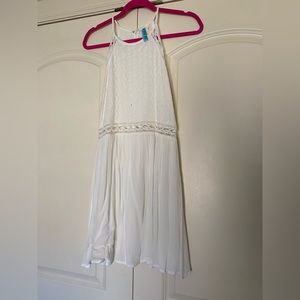 White and lace detailed dress with high neckline and cut out pattern at waist